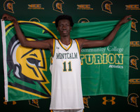 MCC men's basketball player Makur Reclow holds an MCC athletics flag behind his back while posing for a photo.