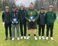 Six members of the MCC men's golf team pose with their championship plaques after winning a tournament.