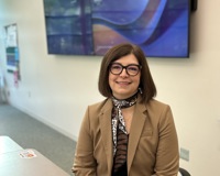MCC English Instructor Erin Busch-Grabmeyer poses for a photo as she sits at her desk.