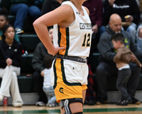 An MCC women's basketball player, with a heavy knee brace on her right knee, holds her hands to her side during a basketball game.