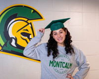 Photo of MCC student in a graduation cap while wearing an MCC sweatshirt.