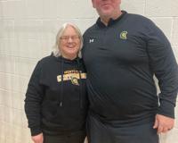 Two basketball coaches wearing Montcalm Centurion long sleeve shirts pose for a photo.