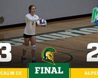 A graphic showing the final score of the MCC volleyball game against Alpena is shown, with MCC winning 3-2. In the background is a picture of an MCC volleyball player serving the ball.