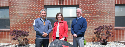 From left, St. Louis High School Principal Ben Brock, MCC English Instructor Erin Busch-Grabmeyer and MCC Dual Enrollment English Instructor/Coordinator Ben Stancil pose for a photo behind the rock outside the entrance of St. Louis High School.