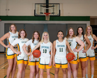 Eight members of the MCC women's basketball team line up in a V-formation for a posed team photo.