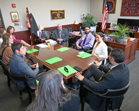 MCC faculty and students sit at a desk in Michigan Senator Rick Outman's office during Capitol Day.