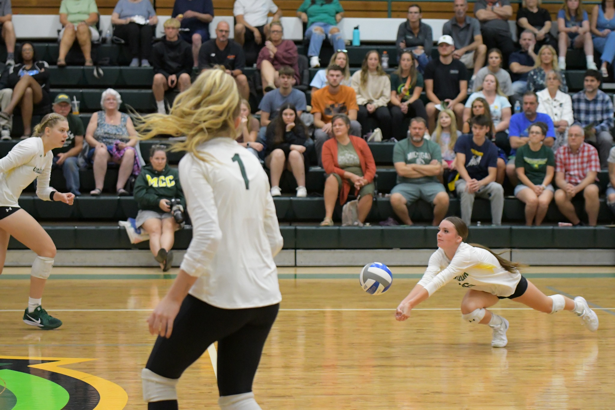 MCC volleyball player dives to hit the ball.