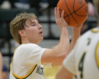An MCC men's basketball player holds the ball slightly above his head right before letting go while attempting a free throw.