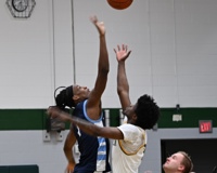 An MCC men's basketball player goes up with his opponent to compete for the opening tip-off.