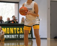 An MCC women's basketball player holds the basketball at her chest while looking at the hoop before attempting a free throw.