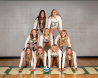 Nine MCC volleyball players form a human pyramid. The bottom row has four players, the middle row has three players and the top row has two players.