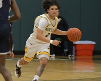 MCC Men's Basketball player, Taylen Carver, running on the court dribbling the ball.