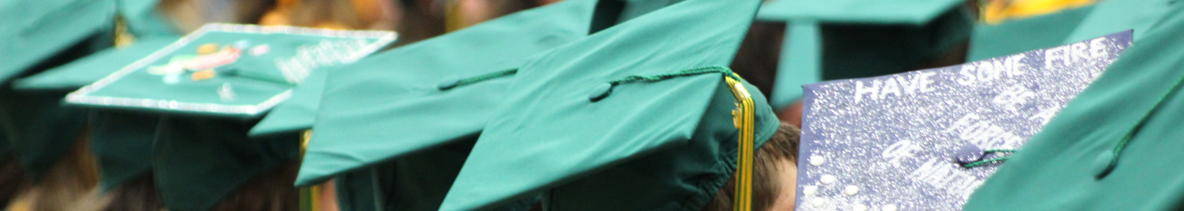 Banner image showing graduation caps on top of the heads of MCC students at commencement ceremony.