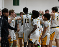 The MCC men's basketball team huddles up for a team breakdown.