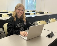 Photo of Larissa Roy working on her laptop