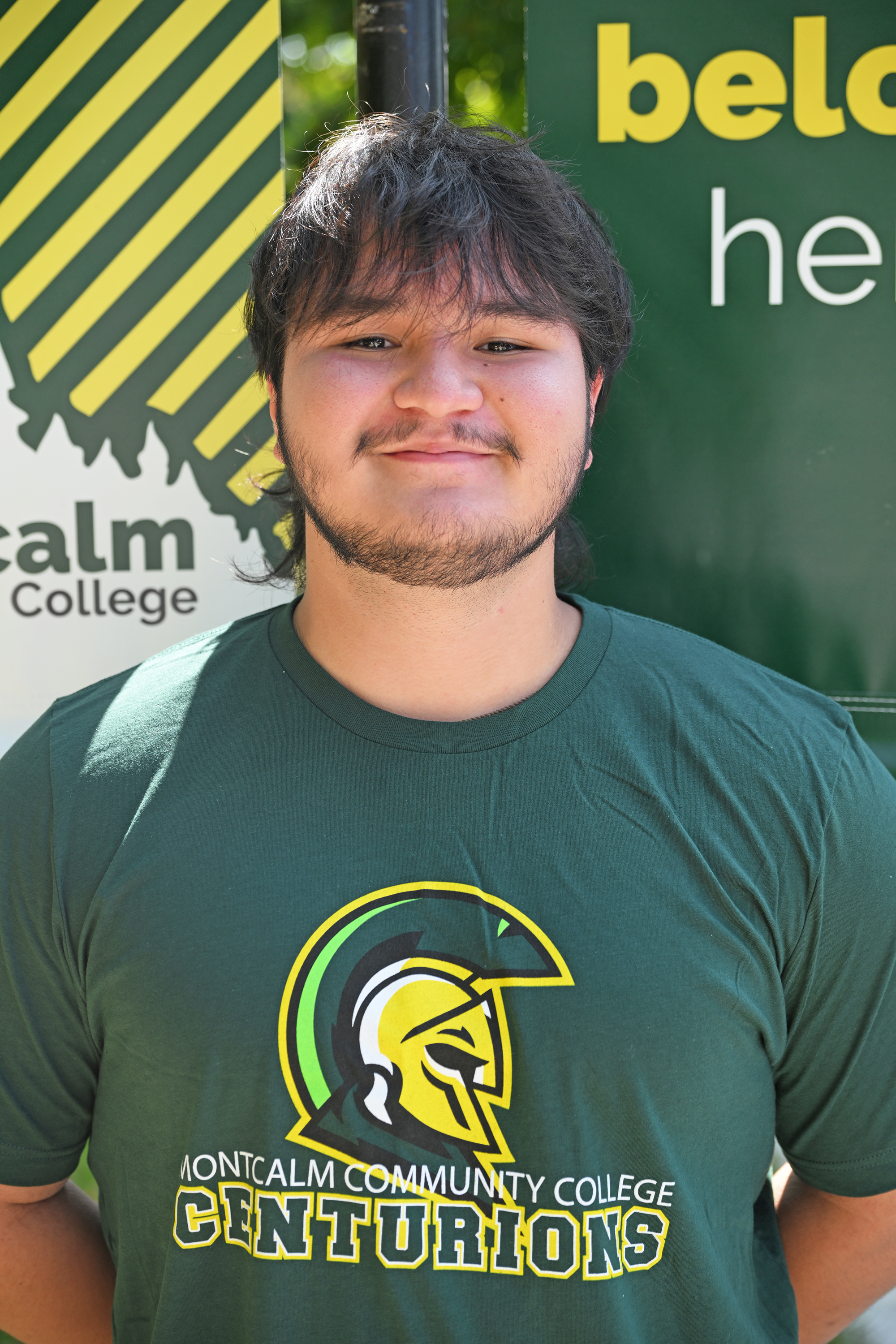 Headshot of Zafar Abduvokhidov wearing a green MCC shirt with the logo.