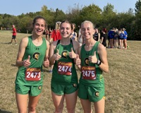 Three members of the MCC women's cross country team each raise two thumbs up and pose for a photo.